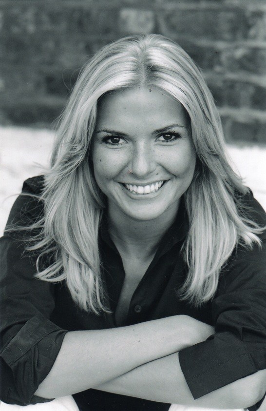 A black and white photo of Lucinda Kennard, a dance teacher in Brighton, smiling at the camera.